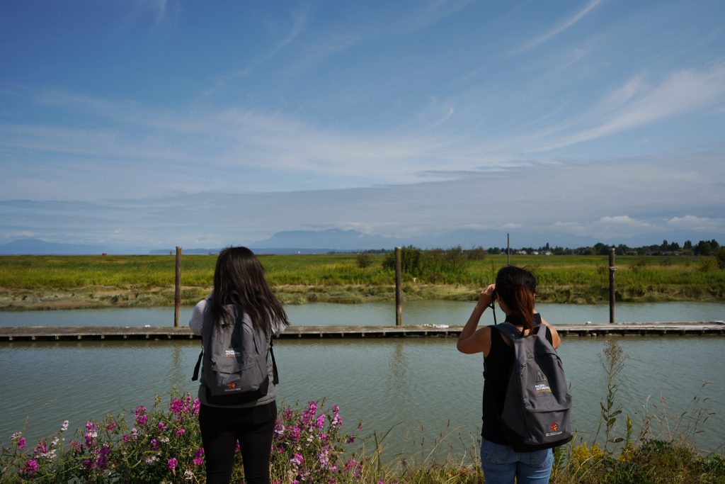 Two young birders looking out over the water with binoculars at Gary Point Park.